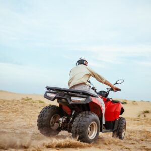 An atv rider racing in desert