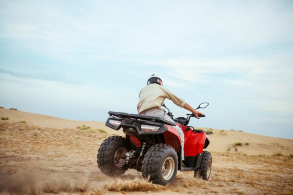 An atv rider racing in desert